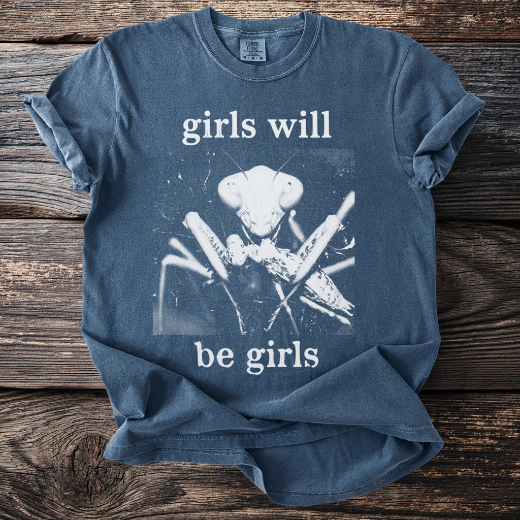 Blue t-shirt with white text "girls will be girls" and a praying mantis graphic.