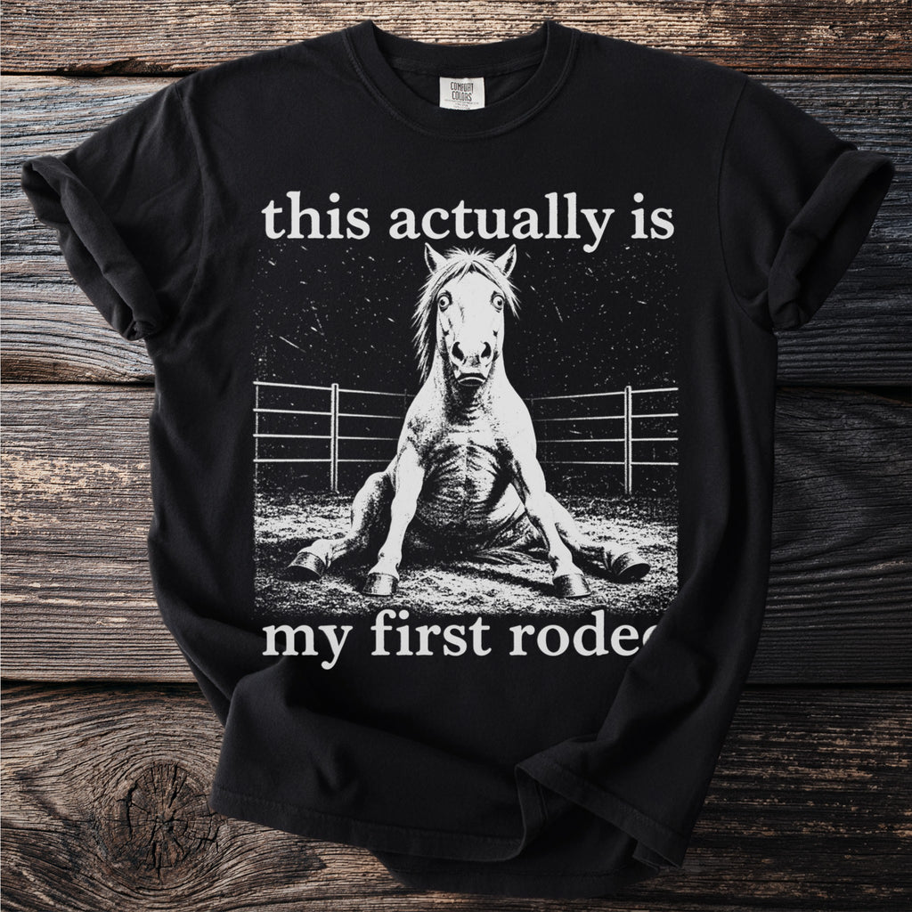 Black t-shirt with a stylized image of a fallen horse and text "this actually is my first rode".