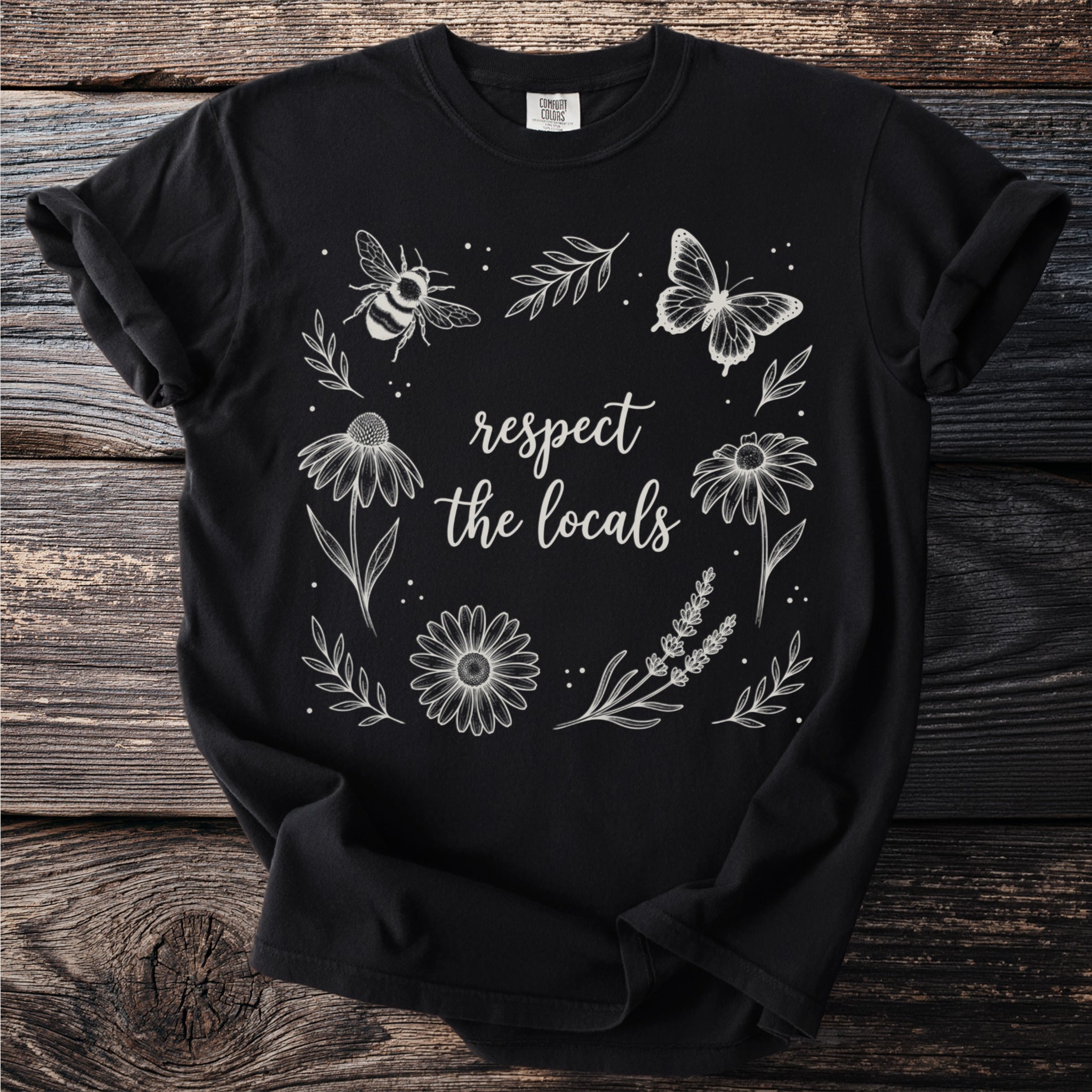 Black t-shirt with white floral elements, a bee, a butterfly, and the text "respect the locals".