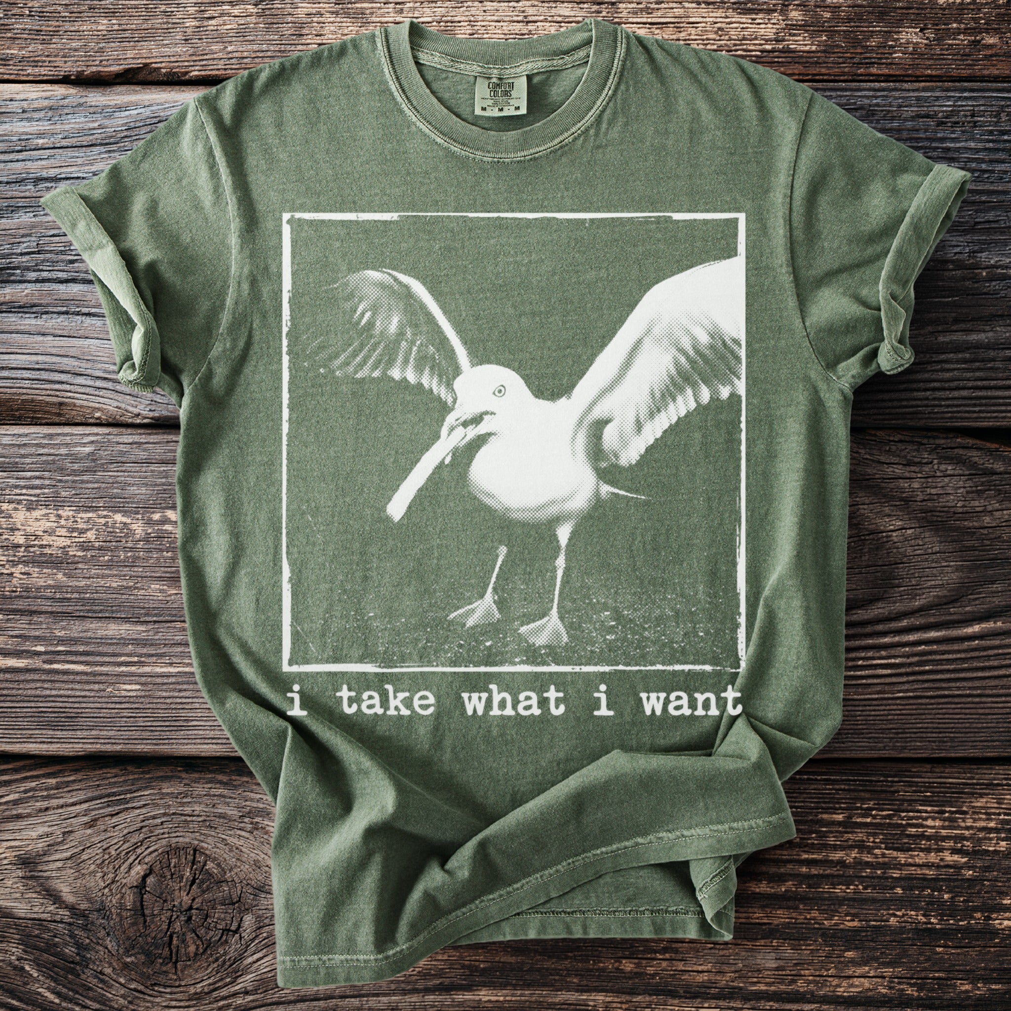 Green t-shirt with white seagull graphic and text "i take what i want".