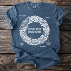 Blue t-shirt with white "Love The Unloved" text and illustrations of natural elements.