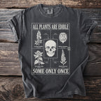 Shirt with skull and toxic plants illustration and text "ALL PLANTS ARE EDIBLE SOME ONLY ONCE".