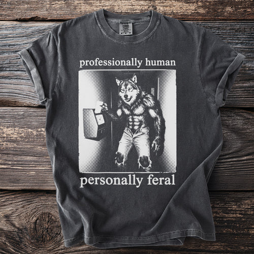 Dark grey t-shirt with a werewolf punching a time clock, text "professionally human personally feral".