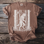 Werewolf graphic on a brown t-shirt with trees, moon, owl, and mushrooms.