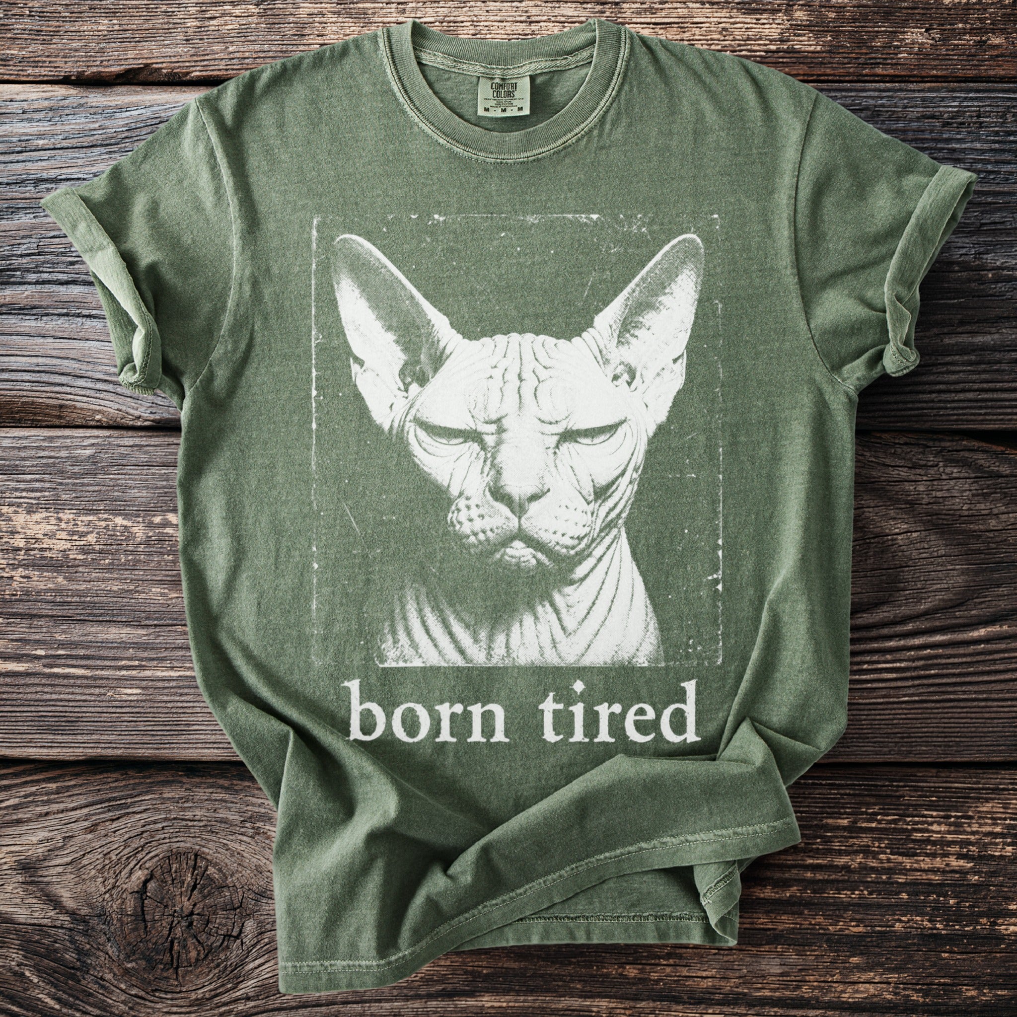 Green t-shirt with a distressed Sphynx cat graphic and "born tired" text.