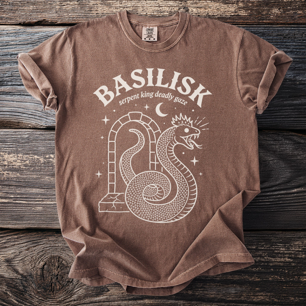 Brown t-shirt with white graphic of a coiled serpent wearing a crown and arch.