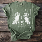 Olive green t-shirt with graphic of two dogs, champagne bottle, and glasses.