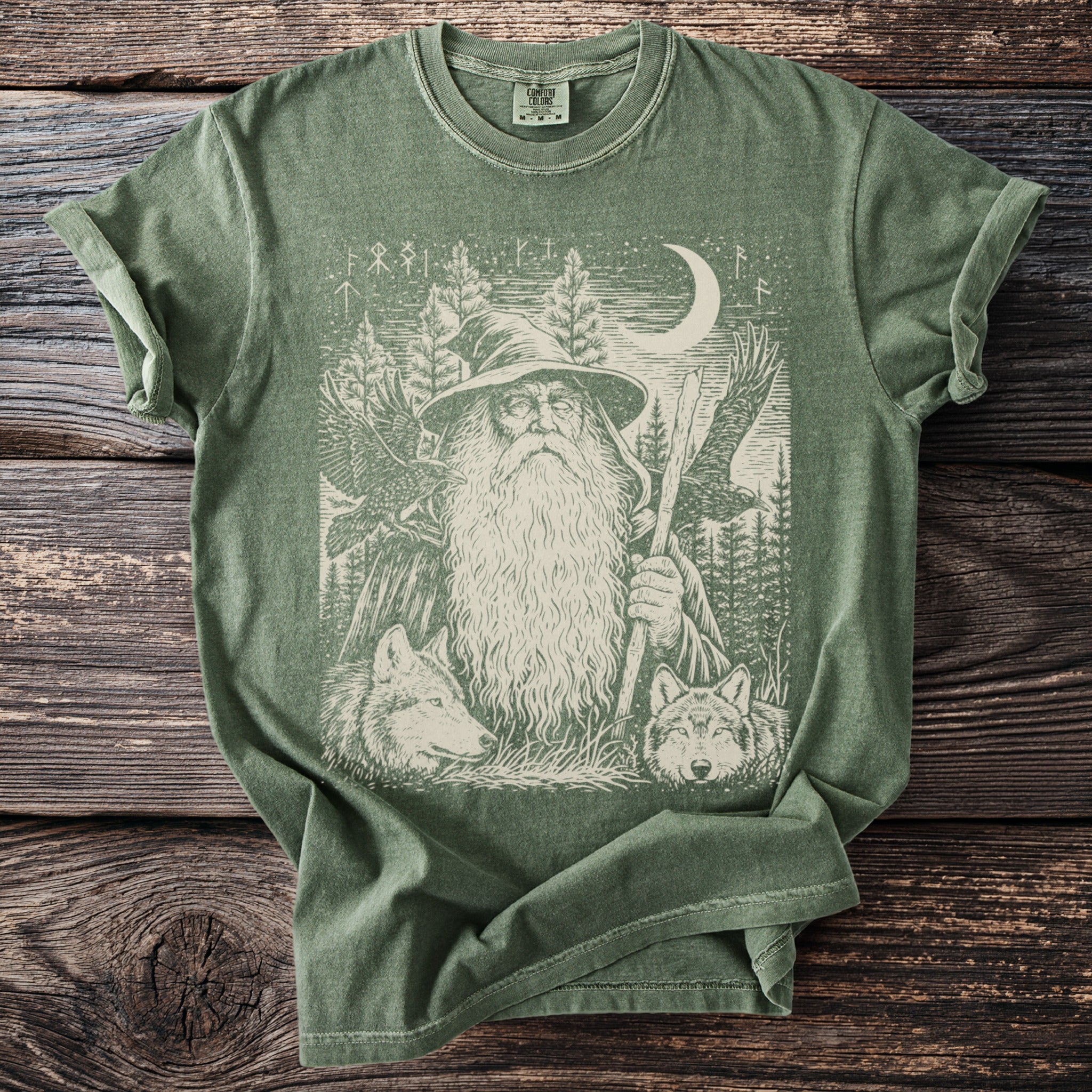 Green t-shirt with wizard, wolves, eagles, trees, moon, and runes graphic.