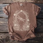 Brown t-shirt with white dragonfly and floral arch design on front.