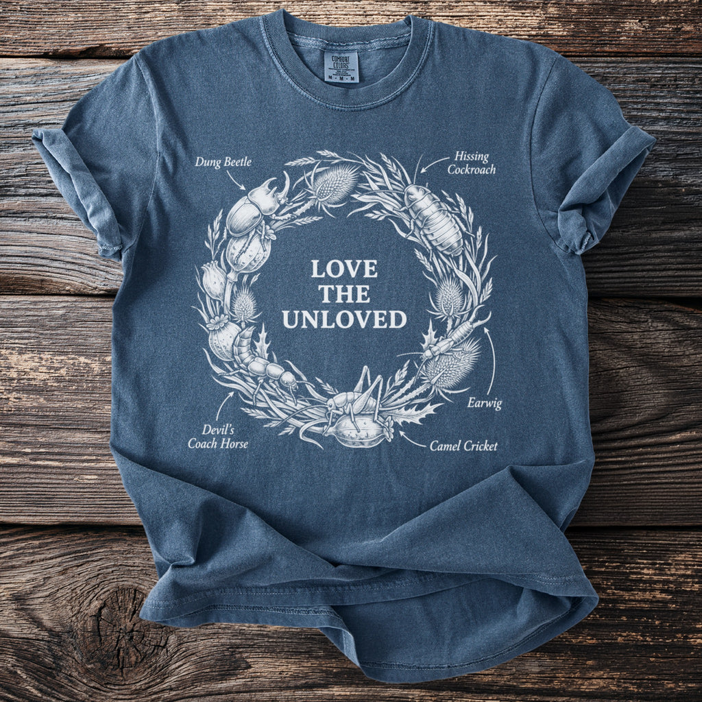 Blue t-shirt with white illustration of insects in wreath and text "LOVE THE UNLOVED".