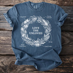 Blue t-shirt with white illustration of insects in wreath and text "LOVE THE UNLOVED".