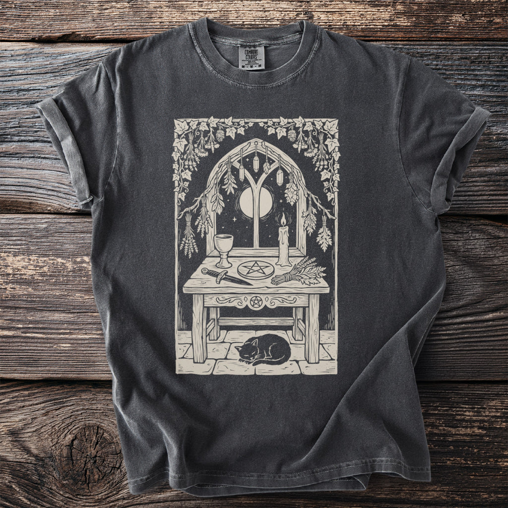 T-shirt featuring a pentagram altar scene with a cat, moon, and candle.