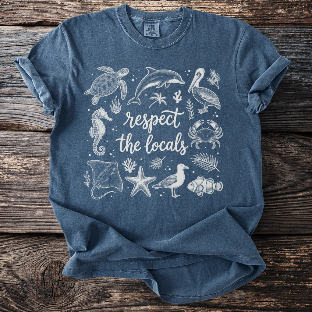 Blue t-shirt with white line art of sea creatures and text "respect the locals".
