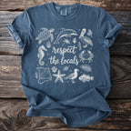 Blue t-shirt with white line art of sea creatures and text "respect the locals".