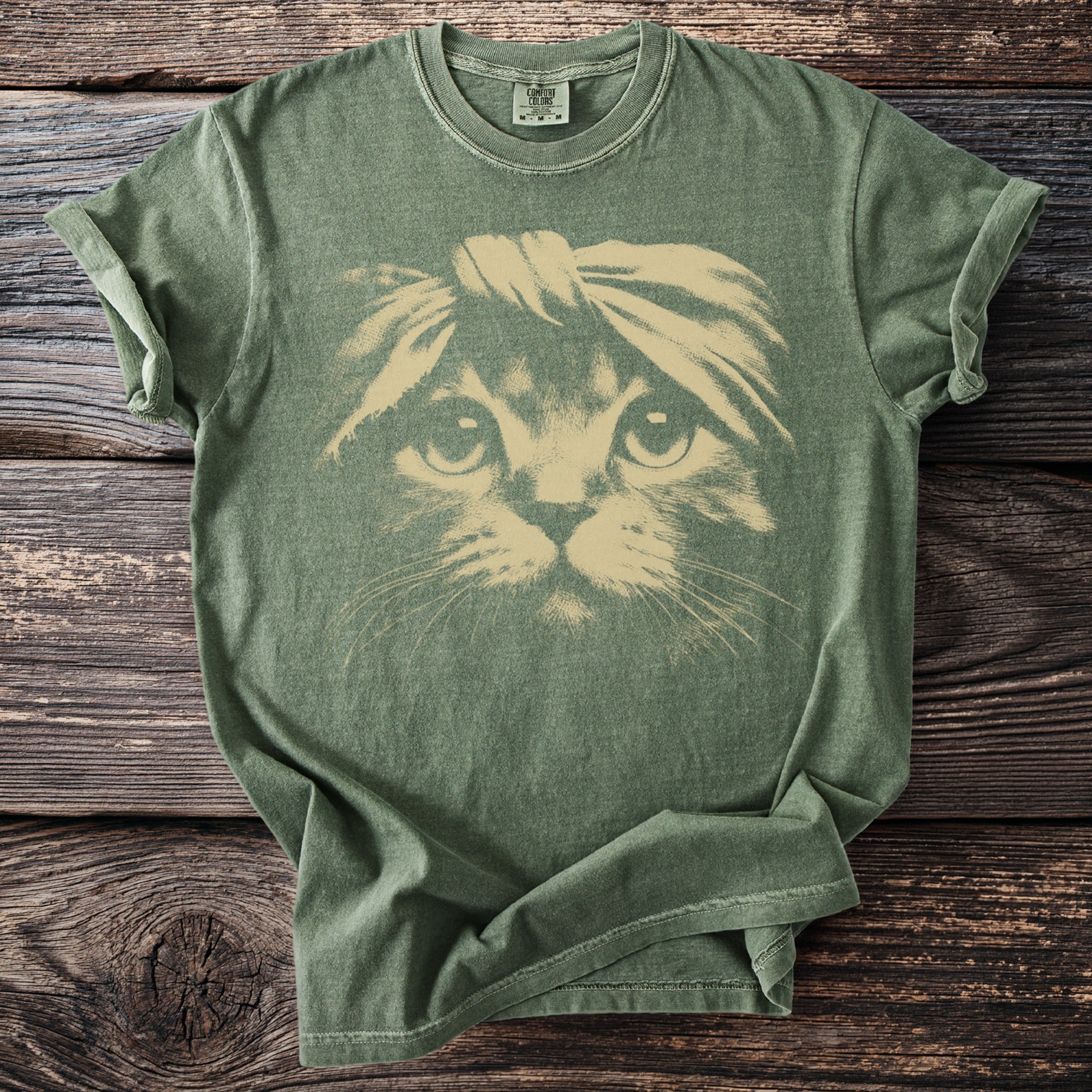 Green t-shirt with a tan cat face graphic wearing a headband.