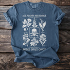 Blue t-shirt with white botanical illustrations and skull, reading "ALL PLANTS ARE EDIBLE SOME ONLY ONCE".