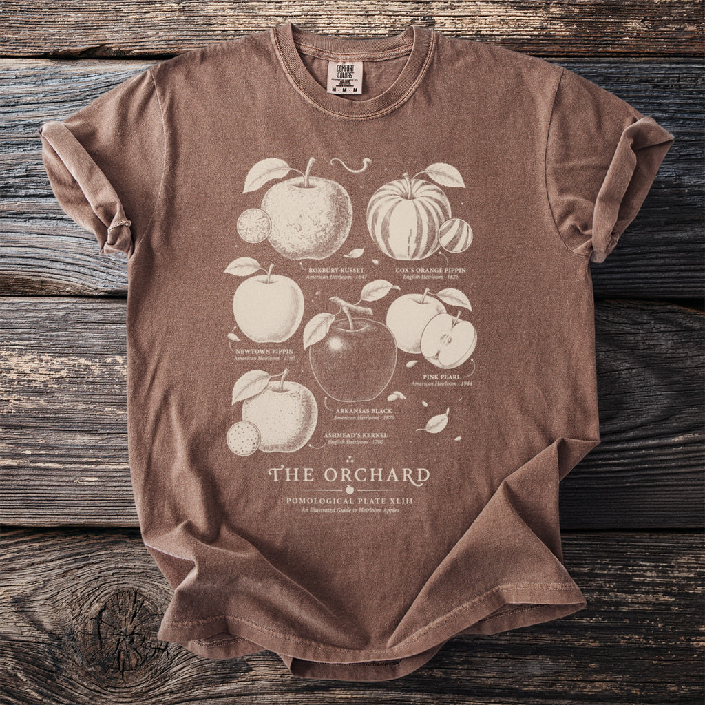 Brown t-shirt with "The Orchard" and illustrated heirloom apples.
