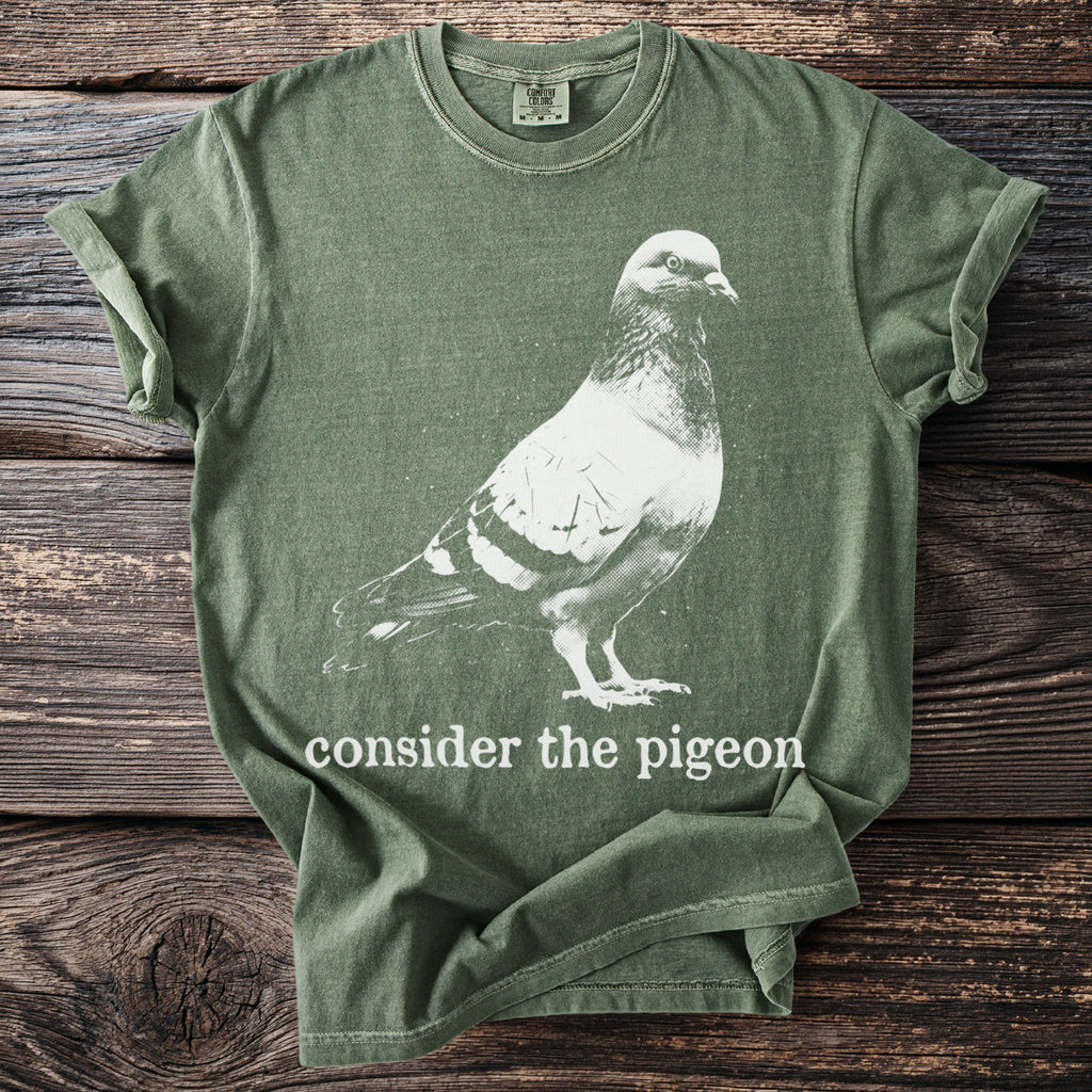 Green t-shirt with white pigeon graphic and "consider the pigeon" text.