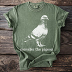 Green t-shirt with white pigeon graphic and "consider the pigeon" text.
