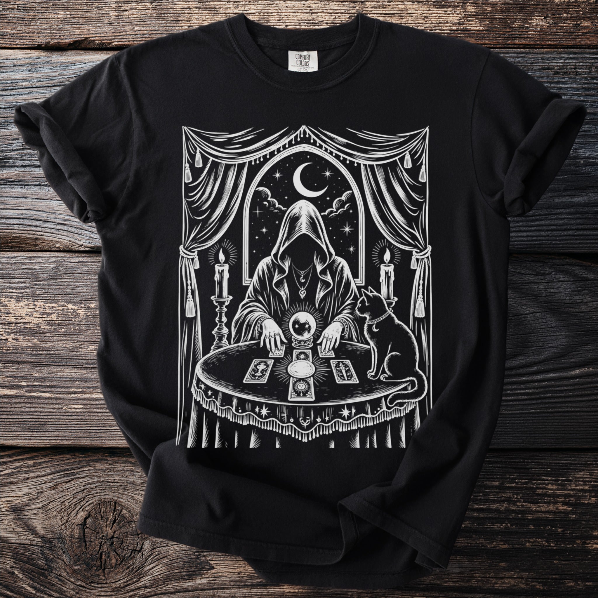 Black t-shirt with white occult image of hooded figure, crystal ball, and cat.