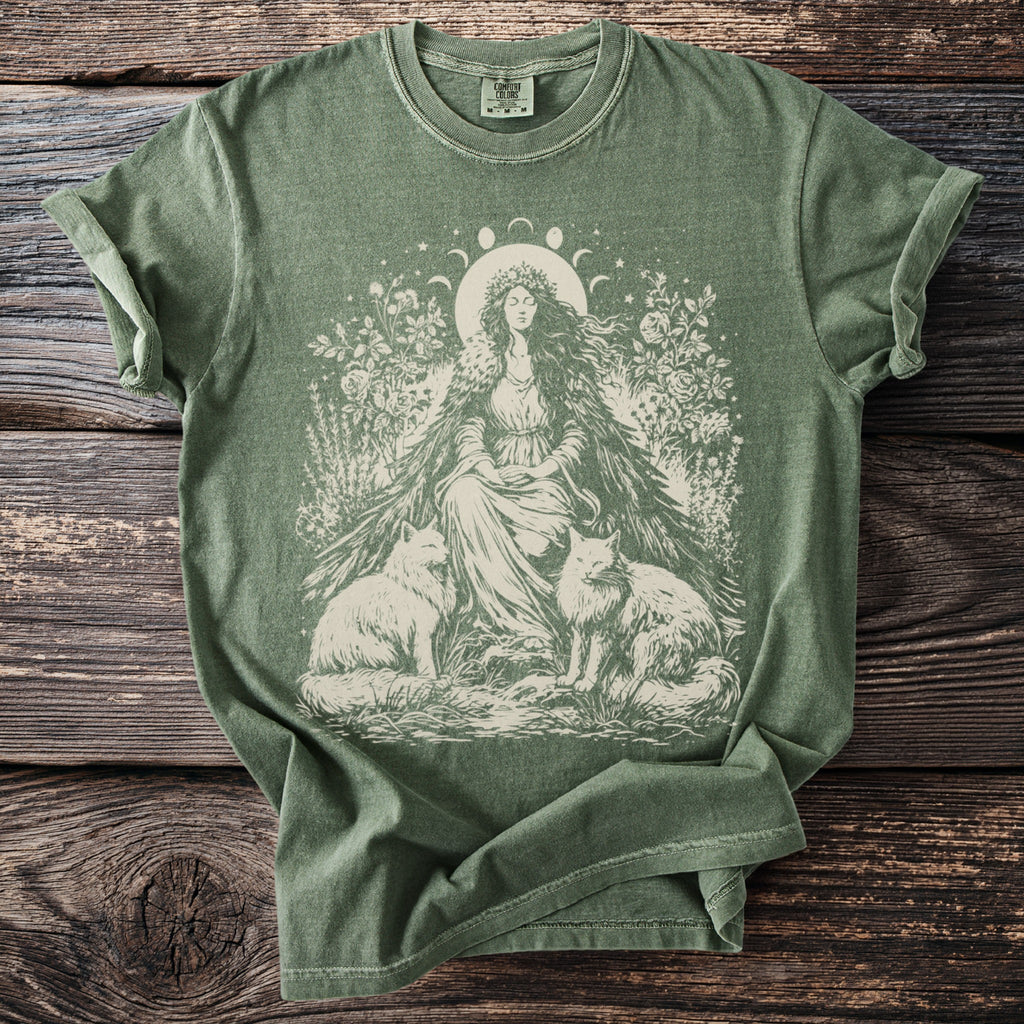 Olive green t-shirt with cream graphic of woman, two foxes, flowers, and moon phases.