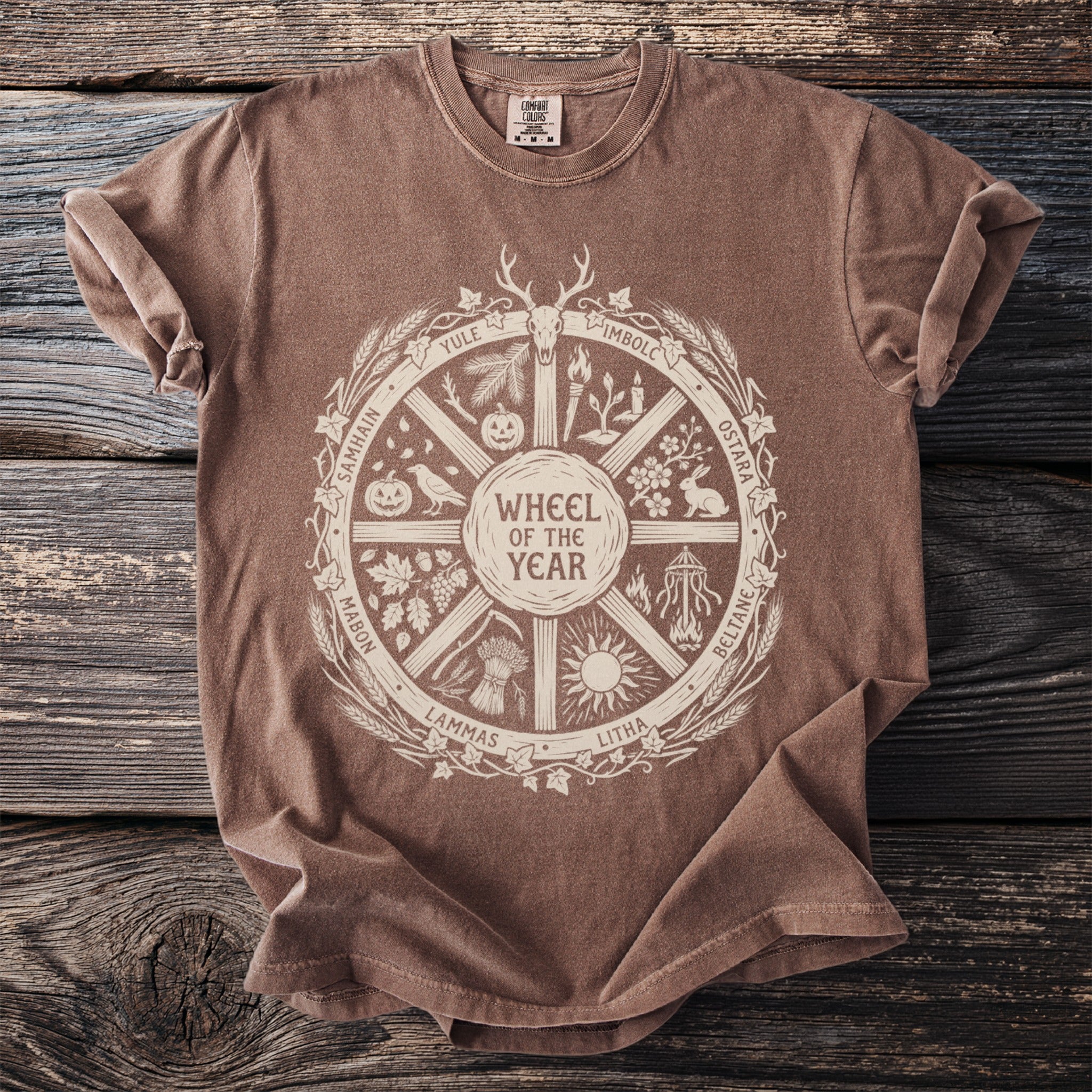 Brown t-shirt with a cream "Wheel of the Year" graphic featuring seasonal holidays and symbols.