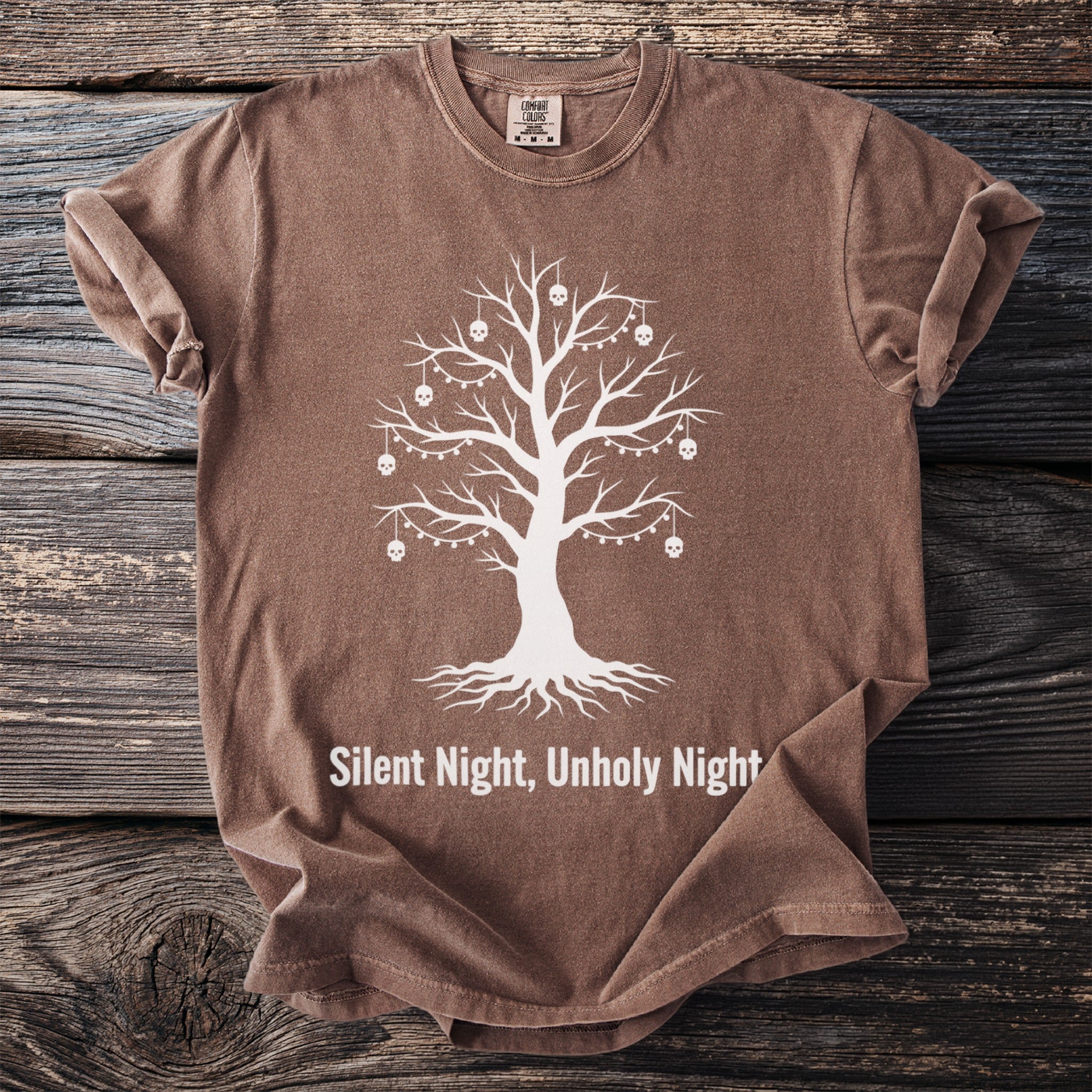 Brown t-shirt with white Christmas tree graphic adorned with skulls and lights.