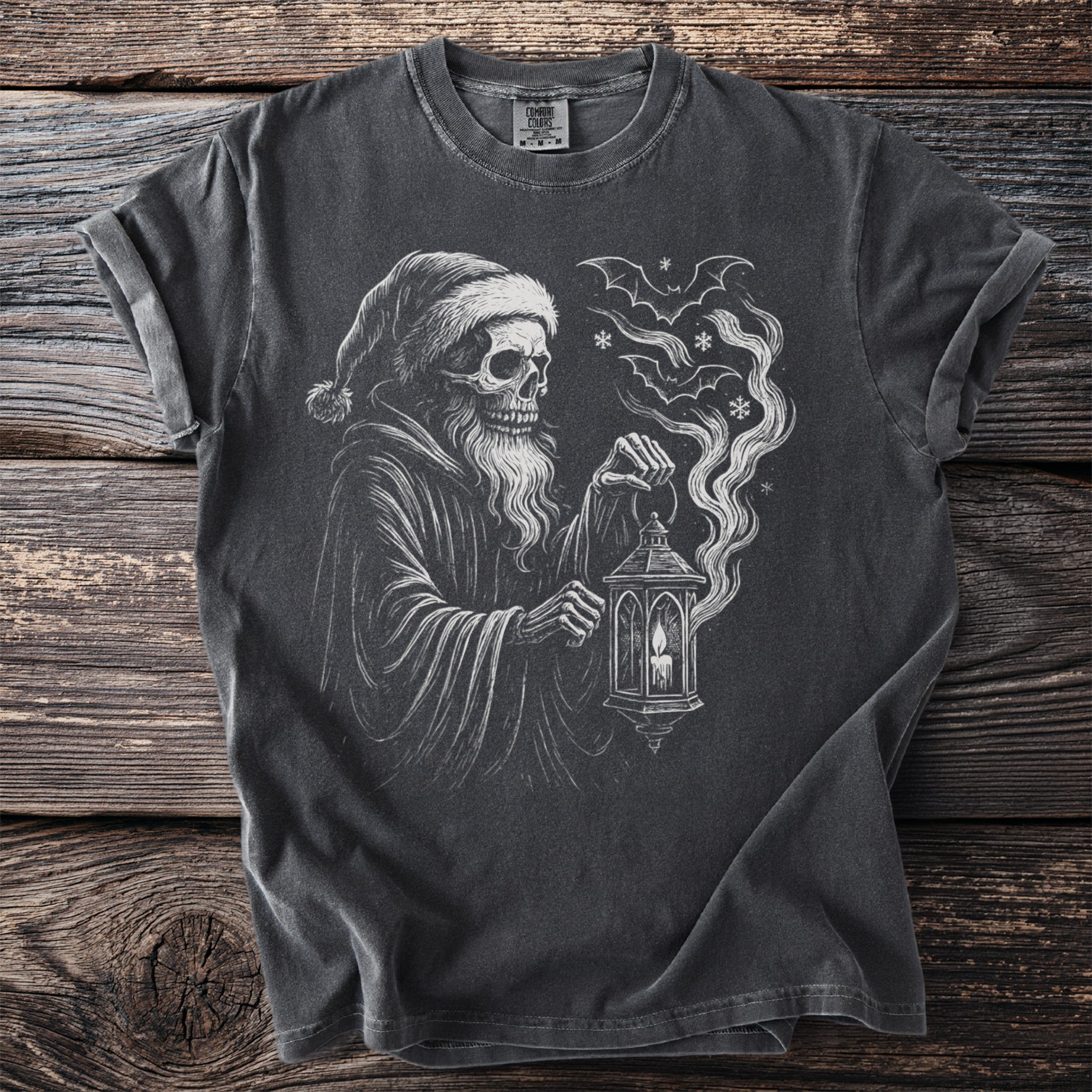 T-shirt with a drawing of a skeleton in a Santa hat holding a lantern and bats.