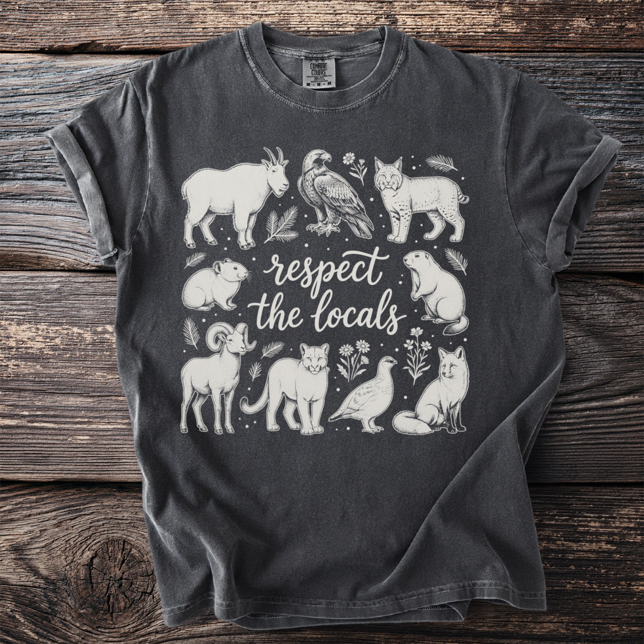 T-shirt with "Respect the Locals" text and mountain wildlife illustrations.