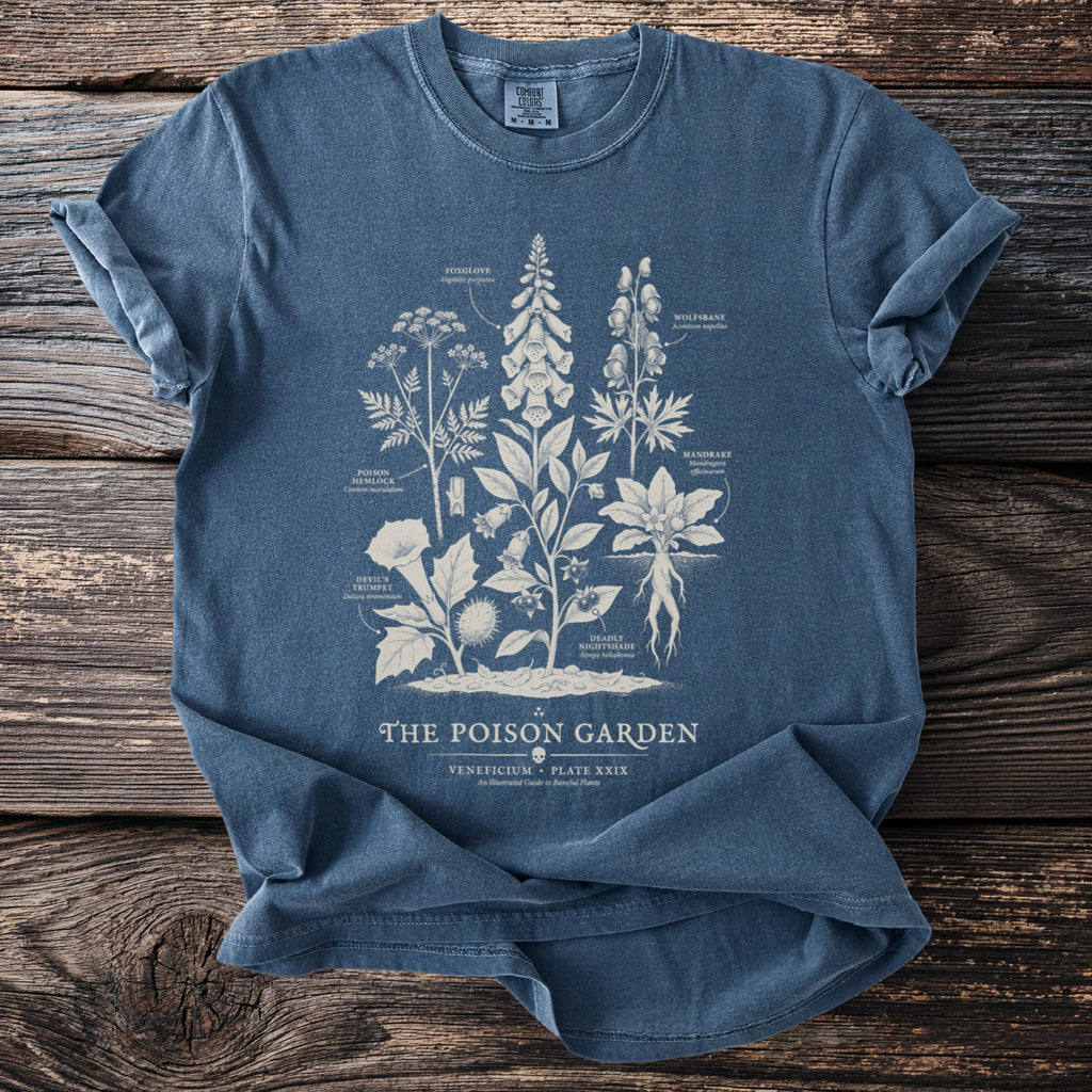 Blue t-shirt with the text "The Poison Garden" and botanical illustrations of poisonous plants.