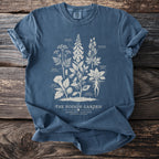 Blue t-shirt with the text "The Poison Garden" and botanical illustrations of poisonous plants.