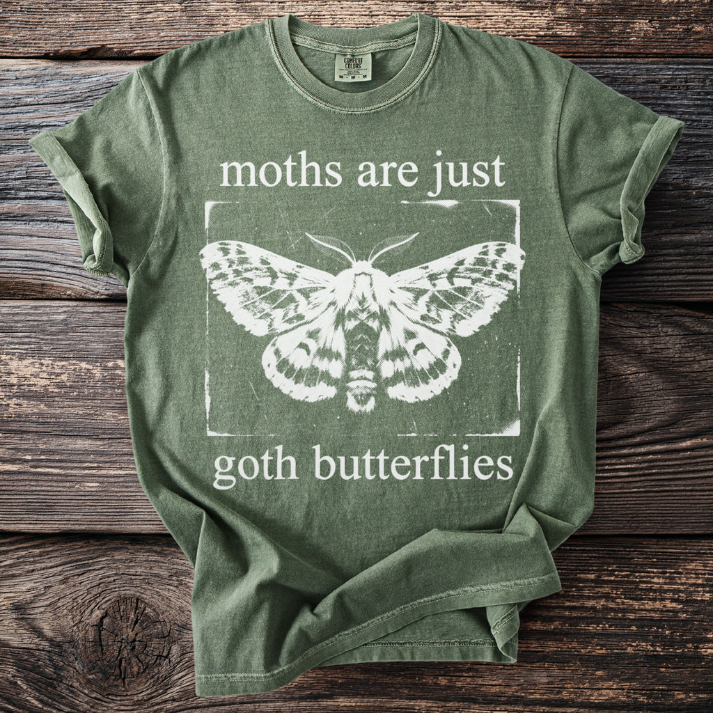 Green t-shirt with white distressed graphic featuring a moth and text "moths are just goth butterflies".