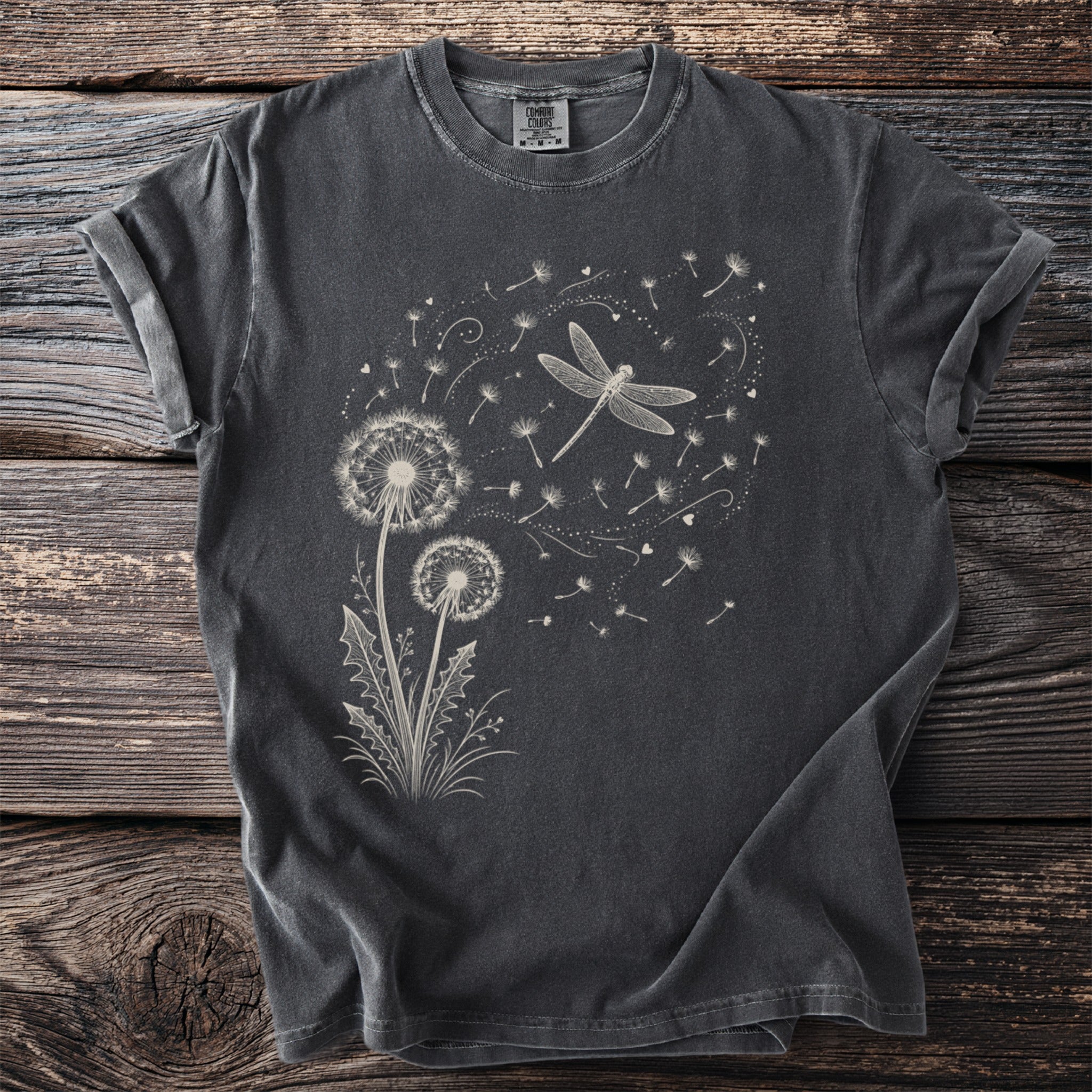 Dark grey t-shirt with white dragonfly and dandelion seed graphic.