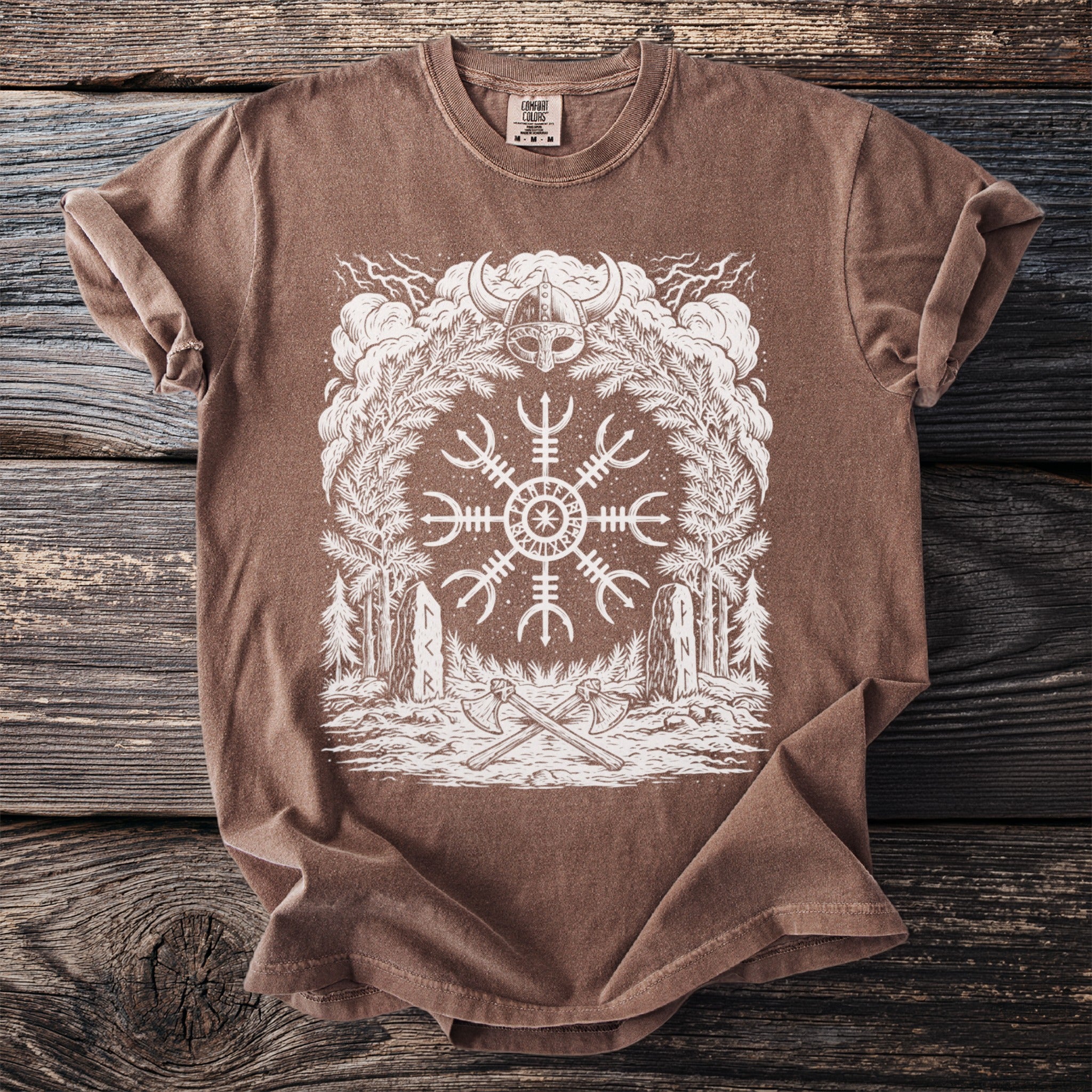 Brown t-shirt with white Viking helm, Norse symbol, trees, axes, and stones graphic.