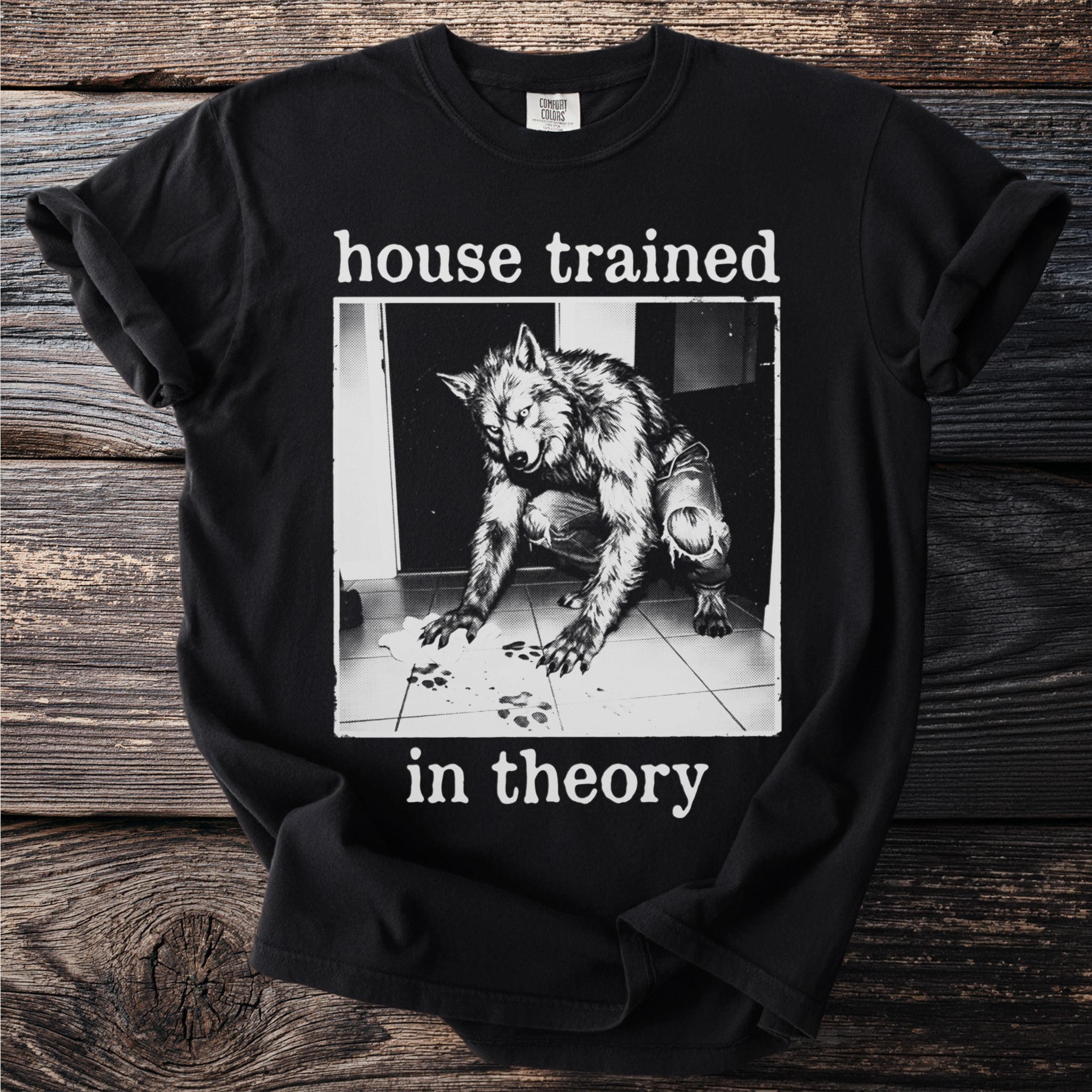 Black t-shirt with a werewolf illustration and the text "house trained in theory".