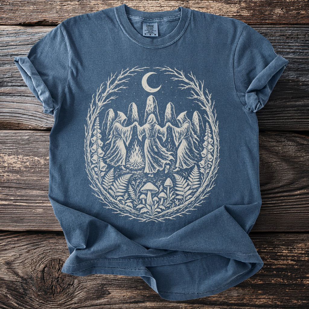 Blue t-shirt with a circular graphic of hooded figures dancing under a moon.