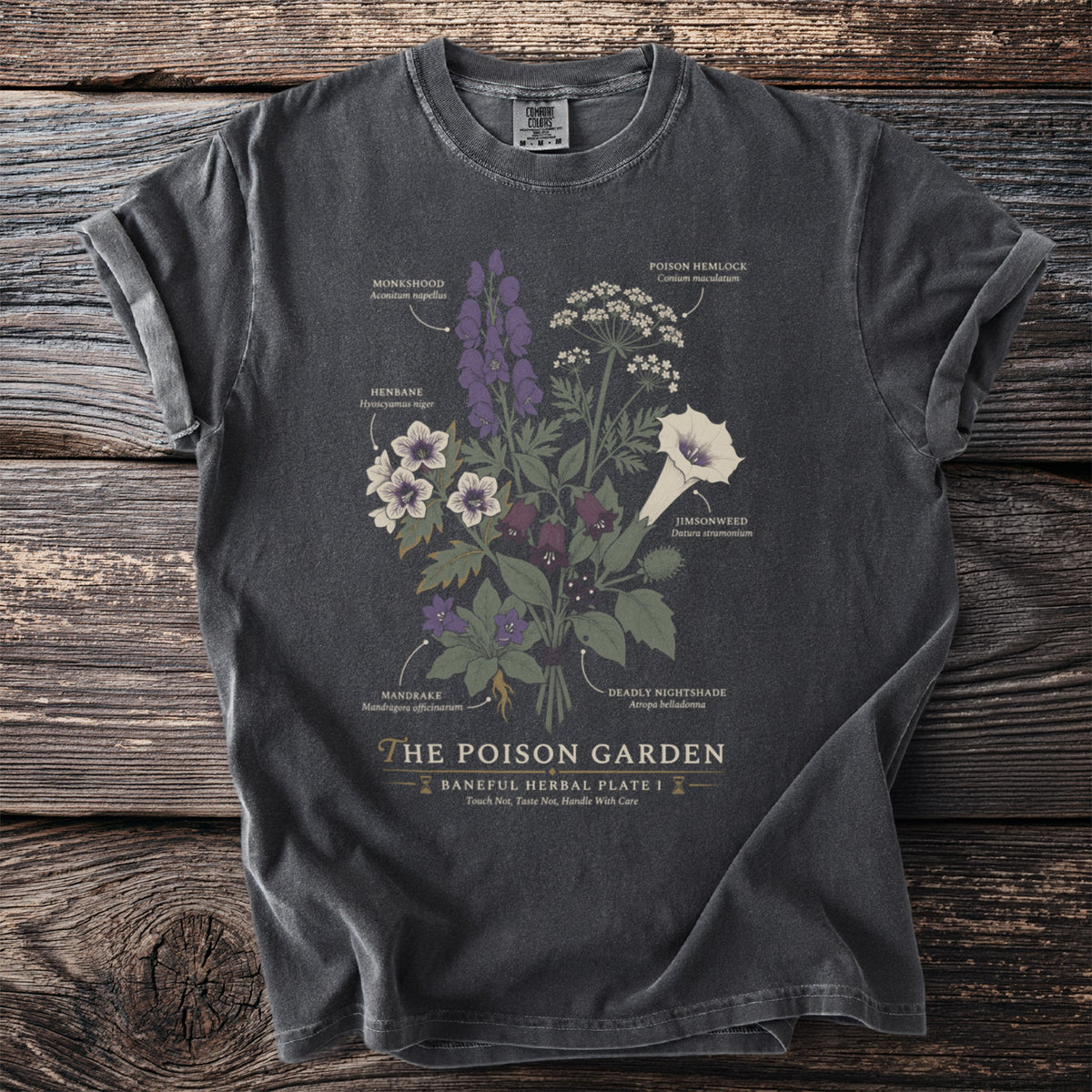 Dark t-shirt with a botanical illustration of poisonous plants and their names, titled "The Poison Garden".