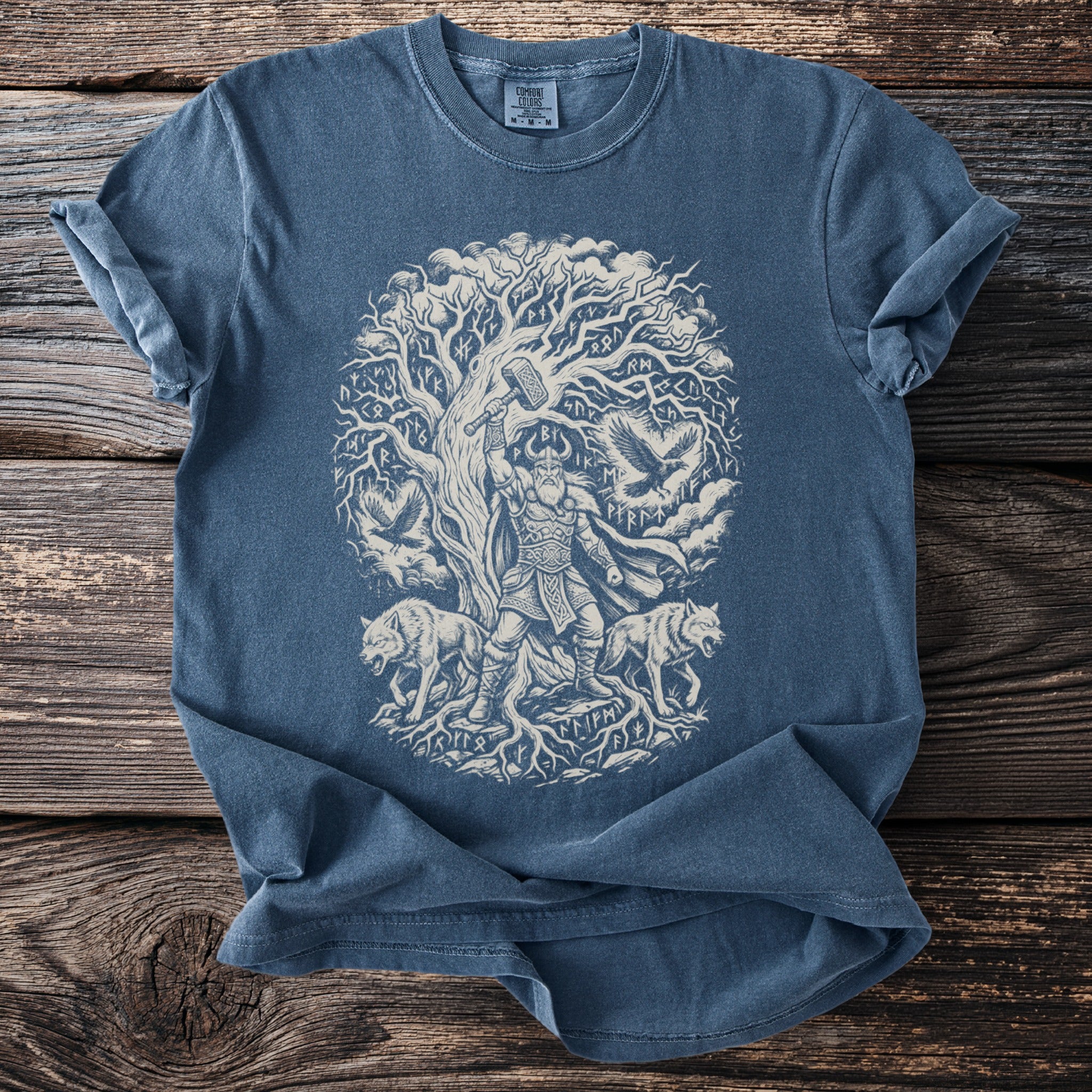 T-shirt with Nordic god, wolves, ravens, and runes beneath a tree.