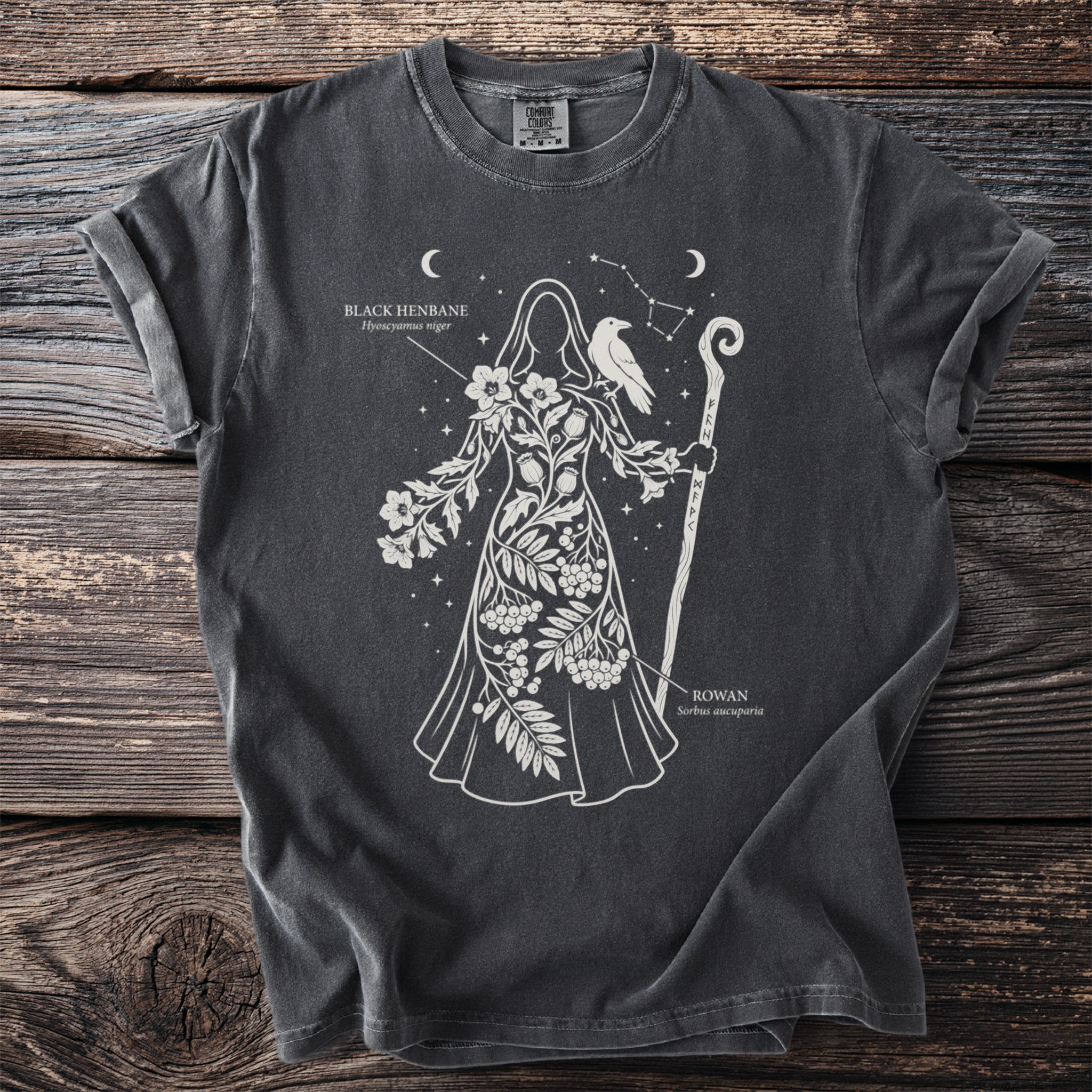 Charcoal t-shirt featuring a white line drawing of a figure adorned with plants and a raven.