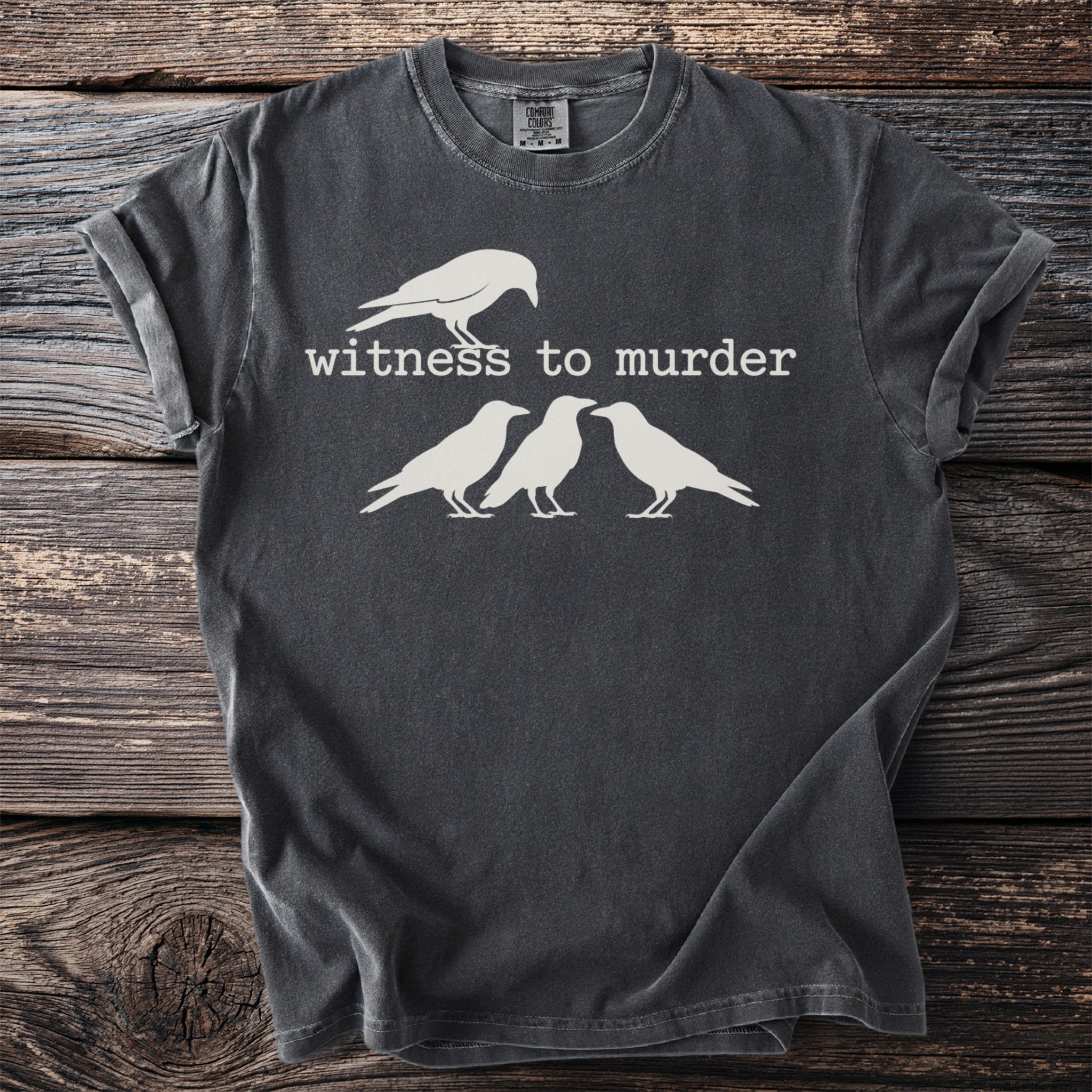 Dark grey t-shirt with white graphic of a crow and text "witness to murder".