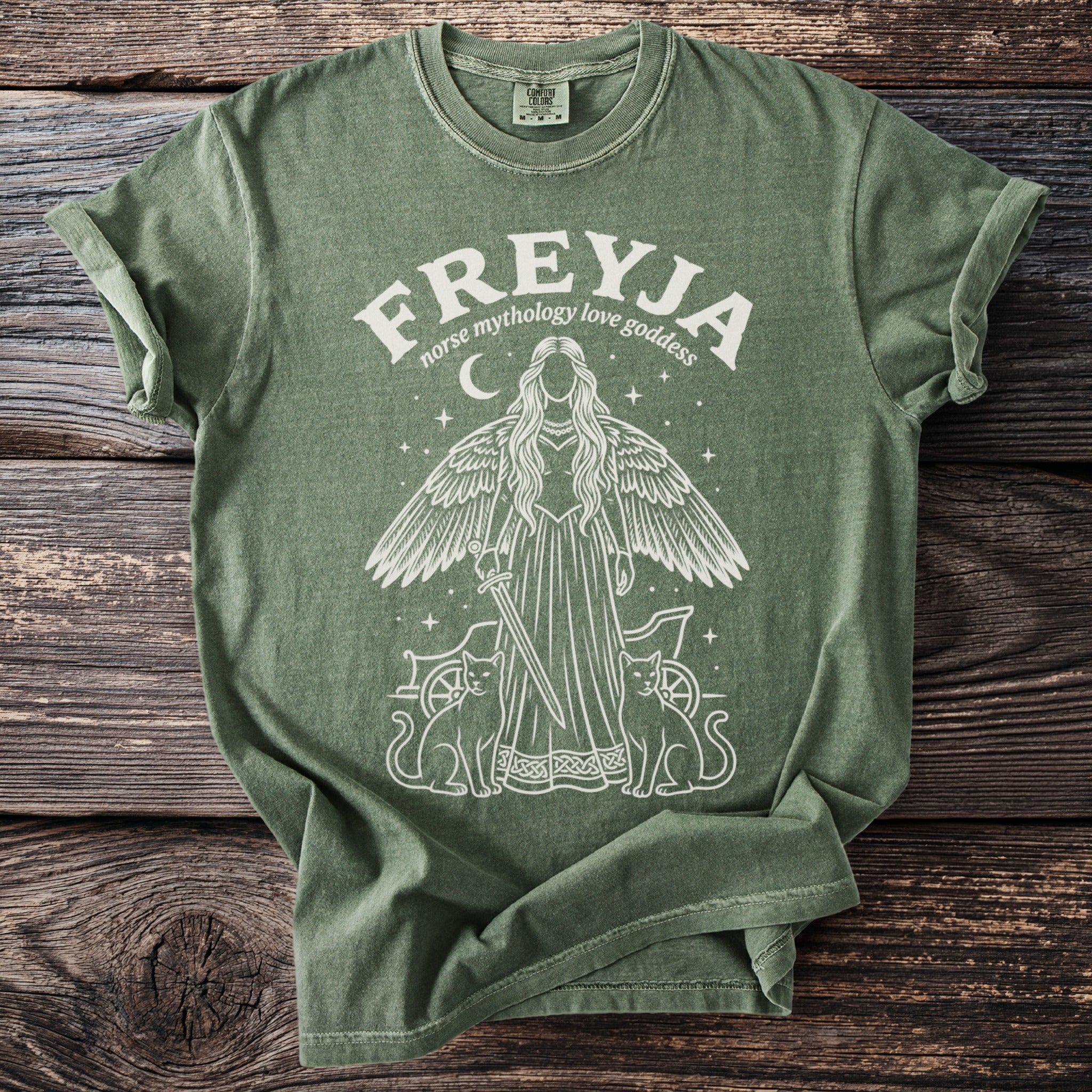 Green t-shirt with a white graphic of Freyja, Norse goddess, with cats and a chariot.