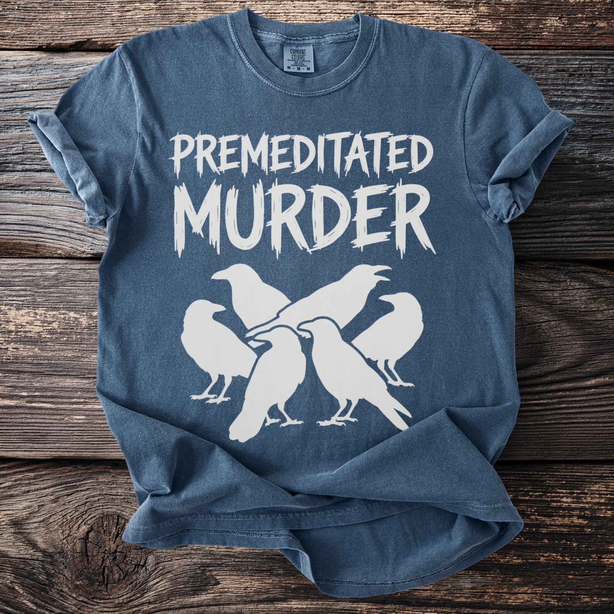 Blue t-shirt with white text "Premeditated Murder" and a group of crows.