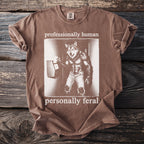 Brown t-shirt with werewolf graphic and text "professionally human personally feral".