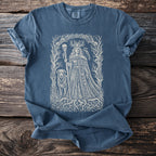 Blue t-shirt featuring a central intricate Norse-inspired graphic of a queen with a dog, raven, and skulls.