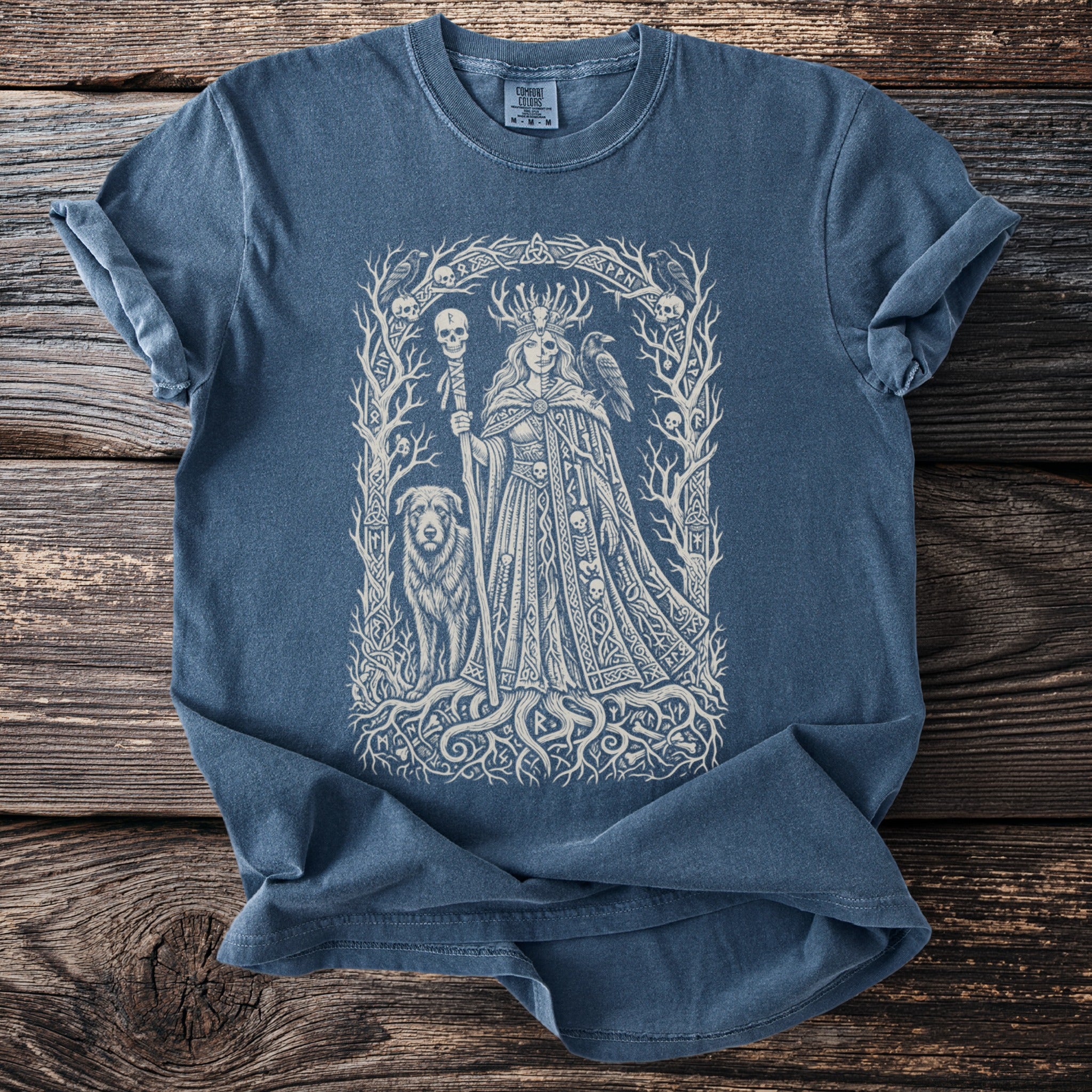 Blue t-shirt featuring a central intricate Norse-inspired graphic of a queen with a dog, raven, and skulls.