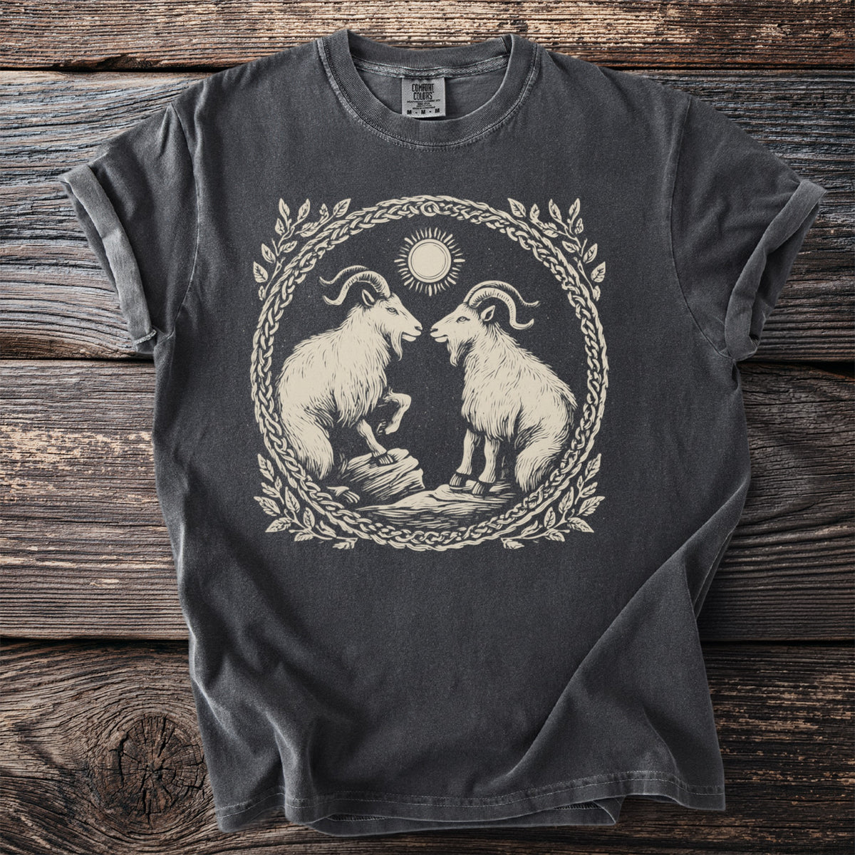 Dark grey t-shirt with a circular graphic of two goats, a sun, and ornate border.