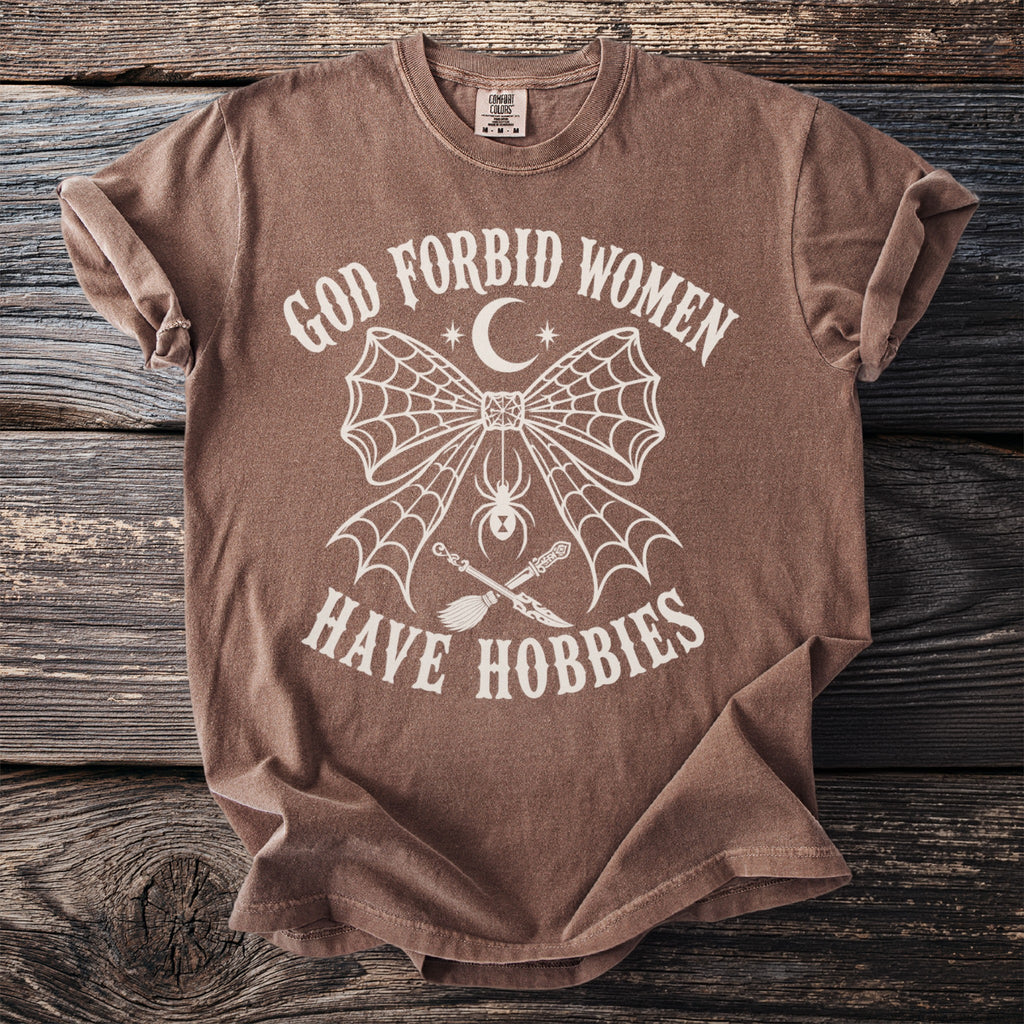 Brown Comfort Colors t-shirt with "God Forbid Women Have Hobbies" text, spider, and occult symbols.