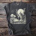 Dark gray t-shirt with a skull-faced scarecrow carrying a lit torch before a full moon, with bare trees and bats.