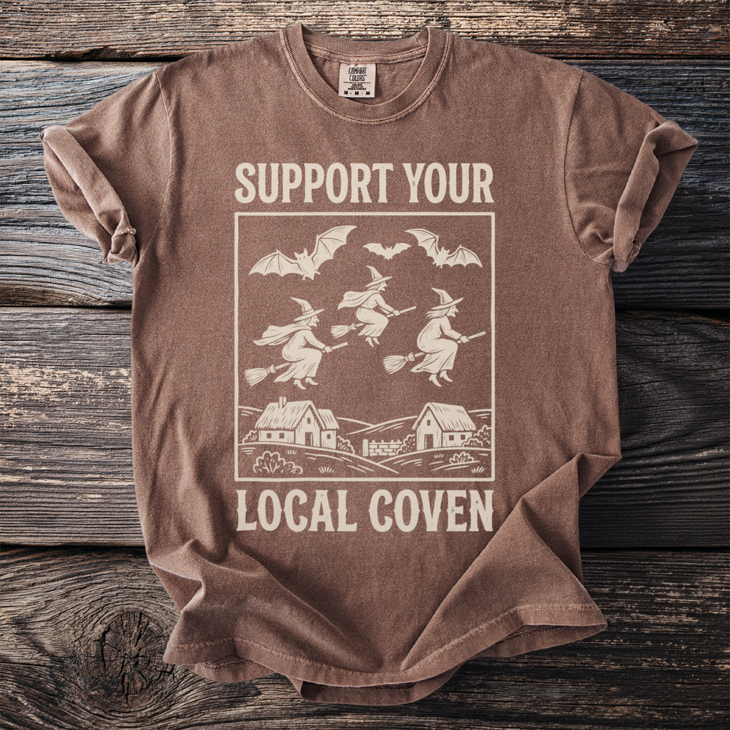 Brown t-shirt with "SUPPORT YOUR LOCAL COVEN" text and witch graphic.