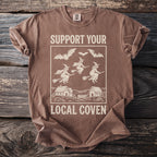 Brown t-shirt with "SUPPORT YOUR LOCAL COVEN" text and witch graphic.